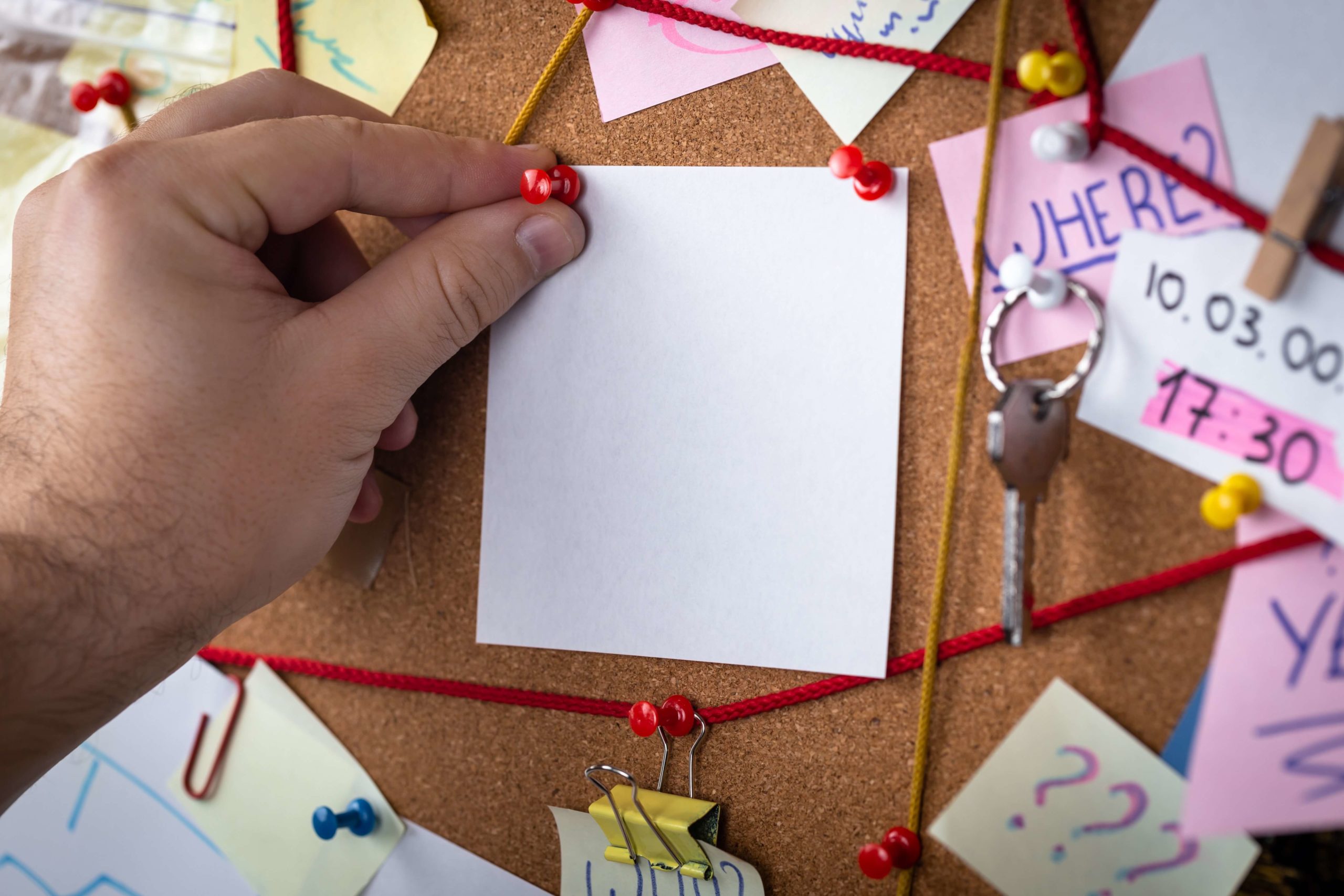 corkboard with paper, hearts and string