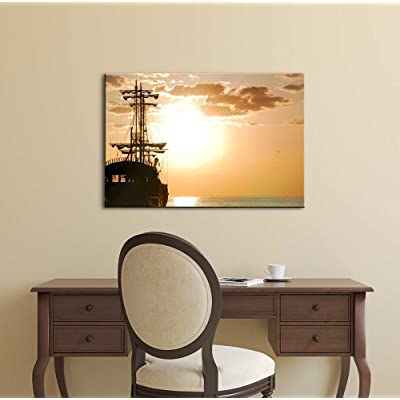 on the wall there are ocean sunet paintings featured on canvas wall art
